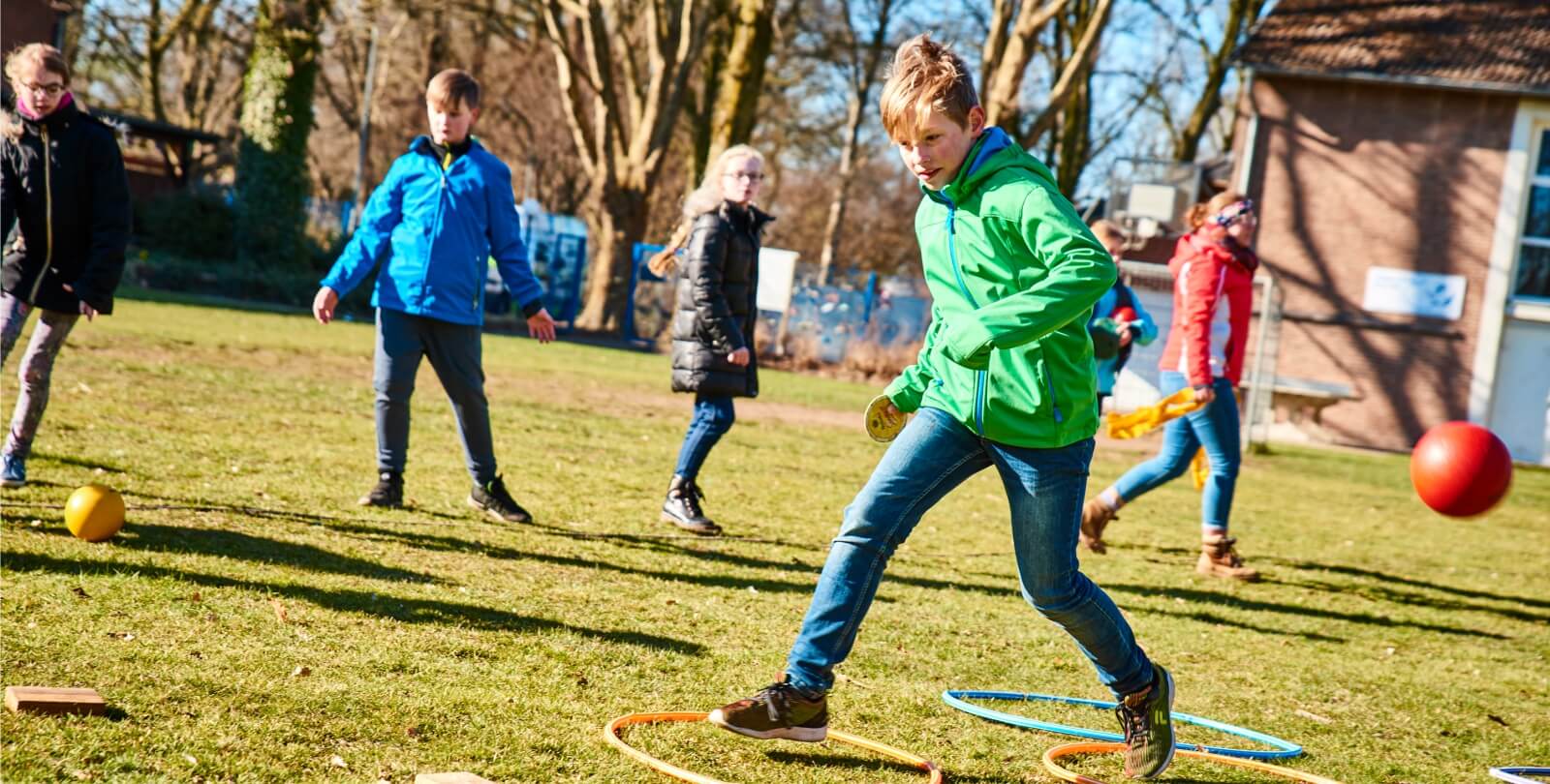Kinder spielen auf der Wiese ein Spiel mit Ringen