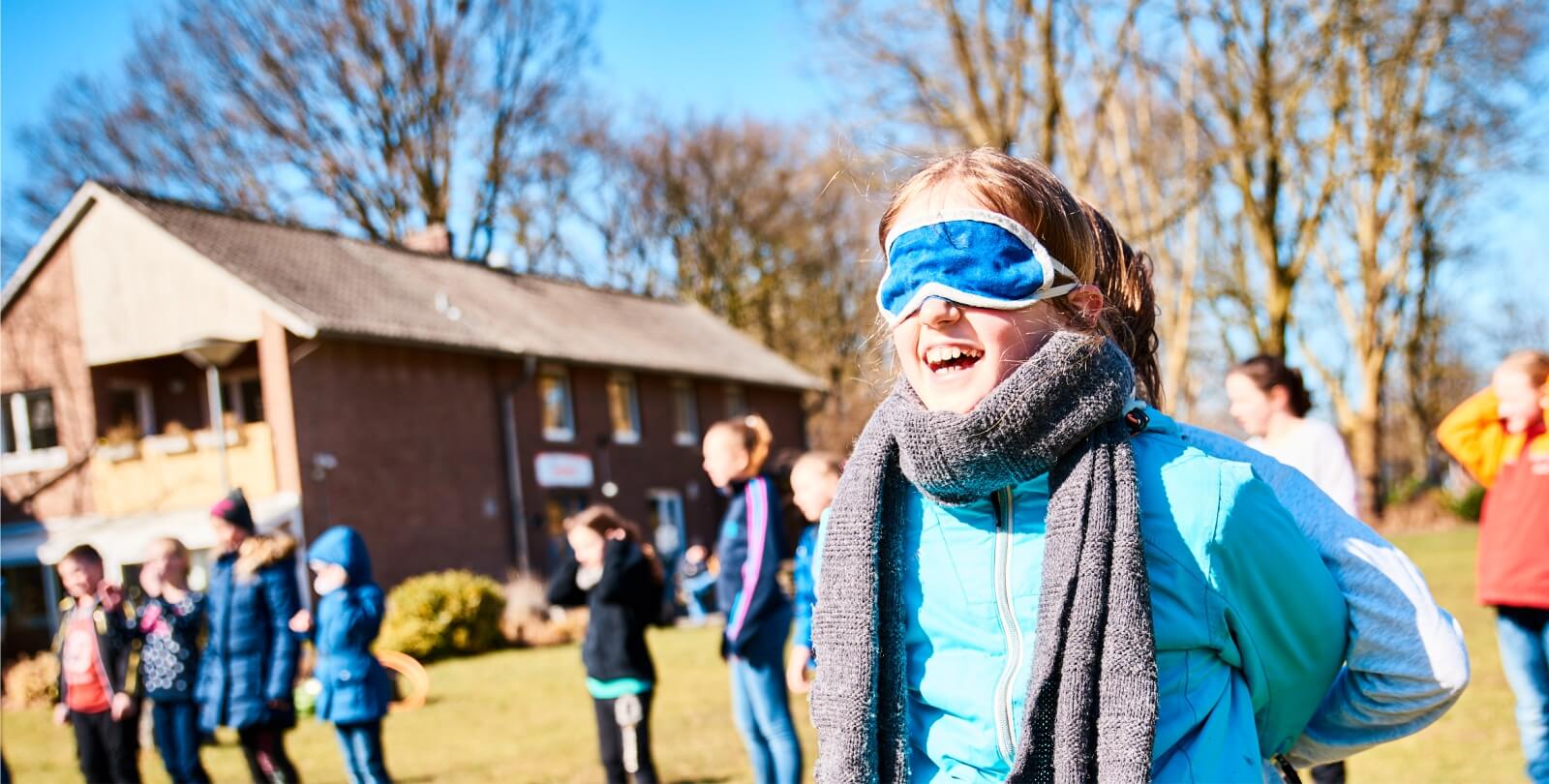 Mdchen im Halbportrt spielt ein Spiel mit verbundenen Augen