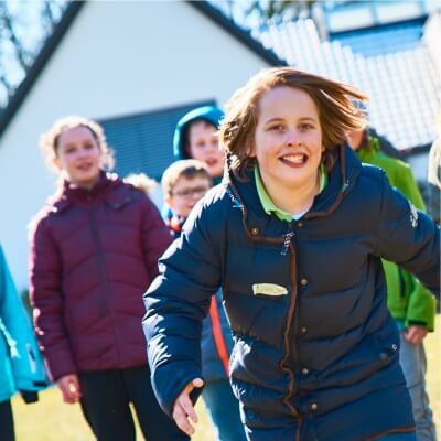Eine Gruppe Kinder luft auf die Kamera zu