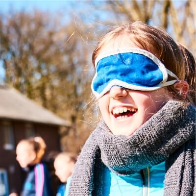 Mdchen im Halbportrt spielt ein Spiel mit verbundenen Augen