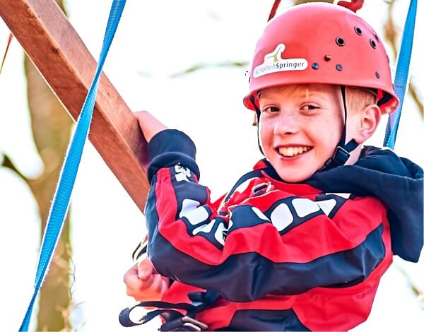 Klassenfahrten Halbporträt eines Jungen beim klettern