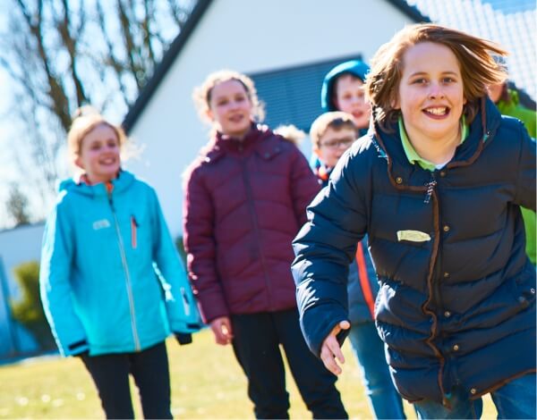 Eine Gruppe Kinder luft auf die Kamera zu